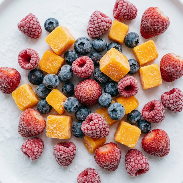 Assorted IQF frozen fruits including berries, mango chunks, and pineapple